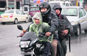 A family during rain in Dehradun on Saturday