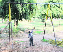 A child looks at a broken swing at the park in Amritsar on Sunday. 