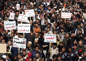 Jordanian protesters hold signs against corruption during an anti-government demonstration in Amman on February 22