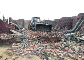An illegal structure is being demolished in an unauthorised colony at Kasan village in Gurgaon district