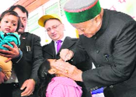 Chief Minister Virbhadra Singh administers polio drops to a child in Shimla on Sunday