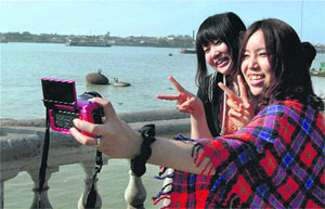 Japanese tourists click themselves near the Ganga in Kolkata on Sunday.