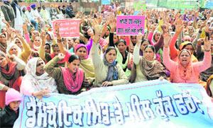 Activists of the mid-day meal cooks union hold a protest outside the district administrative complex in Bathinda on Sunday. 
