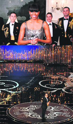 US First Lady Michelle Obama, on a video screen, announces the Oscar for Best Movie along with actor Jack Nicholson onstage on Sunday.  AFP