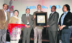 J&K Chief Postmaster General John Samuel felicitates Minister for Medical Education, Youth Services and Sports Taj Mohi-ud-Din during a conference in Jammu on Sunday.