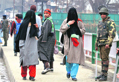 Security personnel stand guard in a Srinagar market on Monday. Security has been tightened after millitants gunned down sarpanch Javid Ahmad Wani at his residence in the Kreeri area of Baramulla district on Sunday night. 