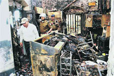 Policemen inspect a  charred room after a mob set the Gulabganj railway station on fire on Tuesday. 