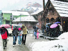 Tourists caught in a fresh snowfall near Manali on Wednesday. 