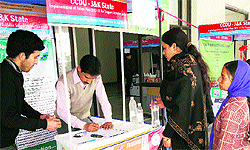 Women from adjoining villages bring in water samples for analysis during a workshop on free water testing held at Reasi on Wednesday