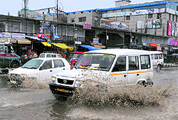 Vehicles wade through a waterlogged road in Srinagar on Wednesday