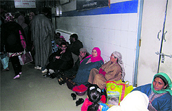 Patients sit in a corridor of a hospital in Srinagar