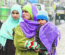 Members of a family are all wrapped up in woollens following heavy rain and snowfall in Kashmir