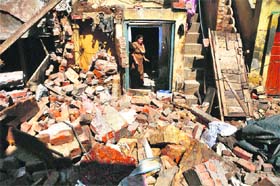 A woman looks at the remains of her demolished house in the Jawahar Nagar camp area in Ludhiana on Wednesday