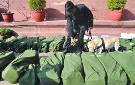 A security man checks the bundles of copies of the Budget 2013-14 before their distribution among the MPs at Parliament House in New Delhi on Thursday