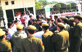 Hero MotoCorp union leaders protest outside the Gurgaon unit on Thursday as policemen look on