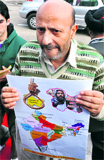 Engineer Abdul Rasheed shows a poster outside the legislative complex in Jammu on Thursday