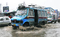 Vehicles wade through a waterlogged road in Srinagar on Thursday.