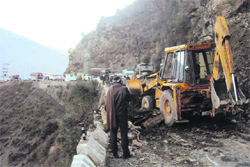 GREF men clear the landslide debris on the Batote-Doda NH in Batote on Friday. A tribune photograph