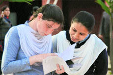 Students of Class XII discuss the question paper after appearing for the English language exam of the Punjab School Education Board in Ludhiana on Friday. 