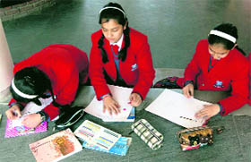 Students of Unison World School participate in a slogan writing competition in Dehradun on Saturday.