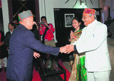 Chief Minister Virbhadra Singh shakes hands with former Union Telecommunications Minister and Anil Sharmas father Sukh Ram at the Raj Bhawan in Shimla on Saturday. 