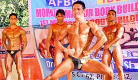 Bodybuilders pose during the Mr Mohalli Bodybuilding Championship.