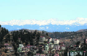 A view of the snow-covered mountains seen from Shimla on Sunday.