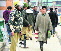 Security personnel stand guard in a Srinagar market on Sunday. Security has been strengthened in the Kashmir valley after the killing of two policemen by militants in Handwara on Saturday.