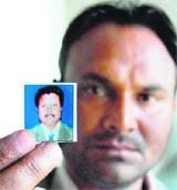 Masihs son Raj Kumar shows his fathers picture.