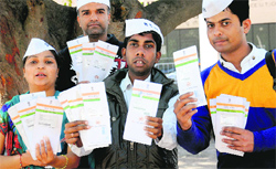 Members of the Aam Aadmi Party show Aadhaar cards found dumped at a barbers shop in Kajheri. Tribune photo: Manoj Mahajan