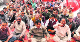 Employees of the Uttarakhand Forest Corporation hold a protest in support of their demands in Dehradun on Monday.