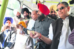 Mayor Harcharan Singh Gohalwaria (extreme left) asks for a ticket on a bus in Ludhiana on Monday. Also seen in picture is MLA Rakesh Pandey (extreme right). 