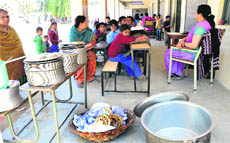 Students wait for the meal at Government Primary School, Bharat Nagar Chowk, Ludhiana, on Monday.