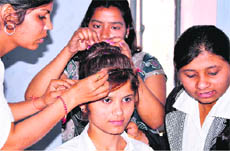 Girls take part in a hair style competition as part of the Youth Week at Shravan Nath Math Jawaharlal Nehru College in Haridwar on Tuesday.