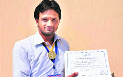 Shiv Charan Naudiyal, student of Uttarakhand Sanskrit University, shows his gold medal and certificate won at the Inter-University Folk Language Vocal event in Haridwar on Tuesday.