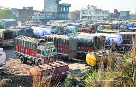 Rows of trucks parked on dusty roads in Transport Nagar