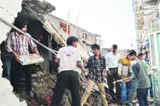 Shopkeepers collect goods from their shops during an anti-encroachment drive.