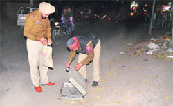 Policemen inspect a briefcase without safety equipment outside Nav Bharti School in Ludhiana on Tuesday.