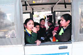 A white maxicab ferries students despite the norm that the colour of a school bus has to be fluorescent yellow with a chocolate strip on its sides, in Amritsar on Wednesday