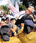 Policewomen try to stop the protesters