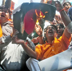 Activists of the Bajrang Dal and Vishwa Hindu Parishad burn placards bearing the Bangladeshi flag during a protest against the recent attacks on the minority Hindu community in Bangladesh, at Jantar Mantar in New Delhi on Wednesday.