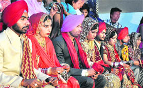 Poor and needy couples tie the nuptial knot at the mass marriage function, organised by the Sukhi Bath Sewa Club at Patara village, near Jalandhar, on Wednesday.