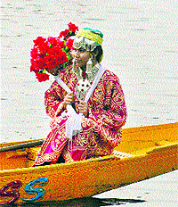 In this file photo, a tourist poses with a bouquet of flowers at the Dal Lake in Srinagar
