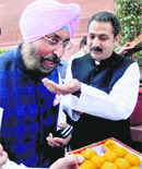 PPCC chief Partap Bajwa distributes sweets at Parliament House in Delhi on Wednesday. PTI