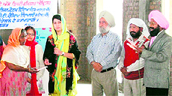 Women being handed over widow pension cards at Maqboolpura in Amritsar on Thursday