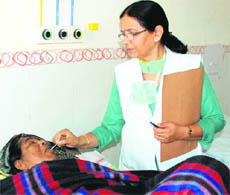 Staff nurse Pushpa Rana attends to a patient at the Civil Hospital, Mani Majra, Chandigarh, on Thursday.