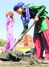 Women working at a construction site on the eve of International Womens Day at Jundla village in Karnal district on Thursday.