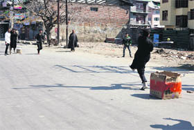 Children play cricket in a deserted street while restrictions are on in Srinagar on Thursday.
