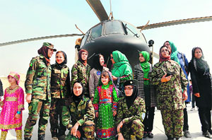 Afghanistans first woman pilot Latifa Nabizada (fourth from left) stands with other women next to a helicopter at the Kabul International Airport on Thursday on the eve of International Women's Day