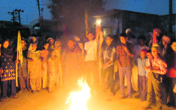 Farmers and labourers burn an effigy of the state government at Kotra Kaura village on Friday. A Tribune photograph